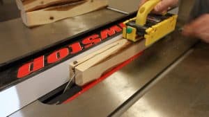 cutting a log into lumber on a table saw